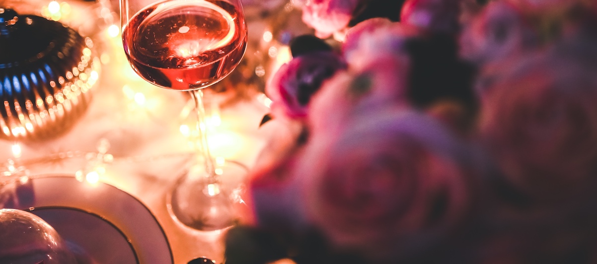 gedeckter Tisch mit Blumen und Weingläsern für ein Candlelight-Dinner