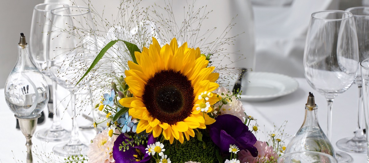 gedeckter Tisch mit sommerlichem Blumengesteck
