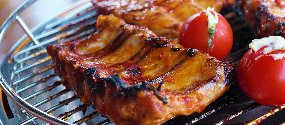 Grillfleisch und Tomaten auf Grillrost